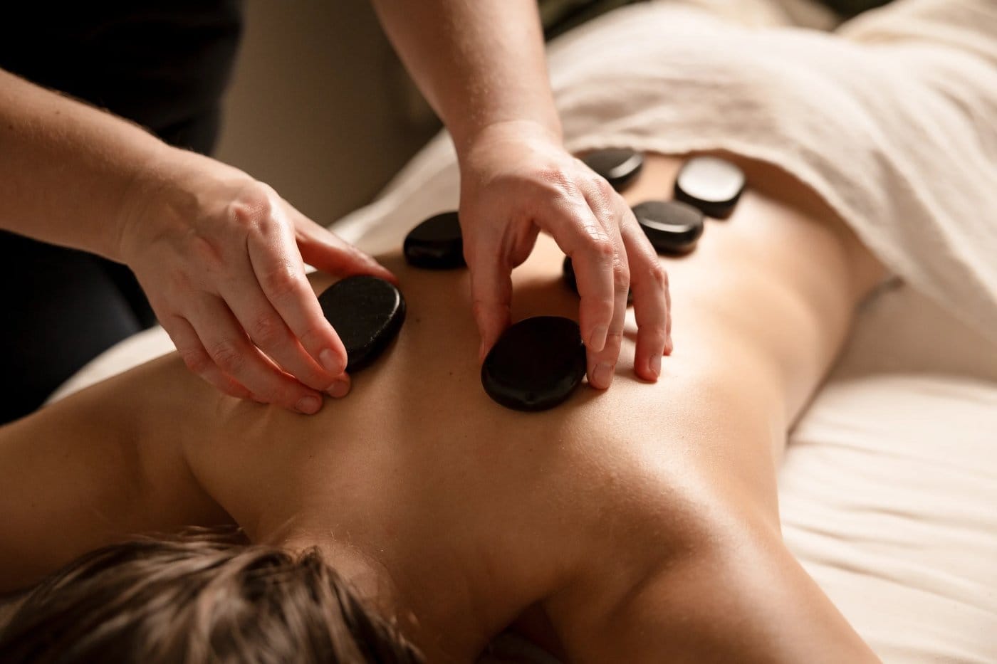 Warm stones placed along a guest's back during a hot stone massage session