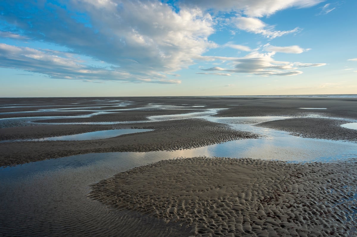 Sand at low tide with pools of water and ripples near Qualicum Beach on Vancouver Island